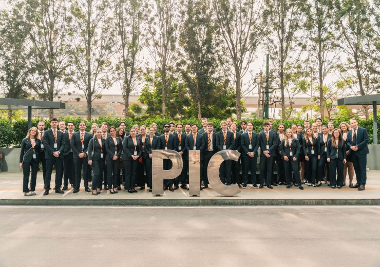 Groepsfoto van hospitality studenten in pak voor het Philips Innovation Campus-logo, symbool voor ambitie en toekomstgericht onderwijs bij EuroCollege.